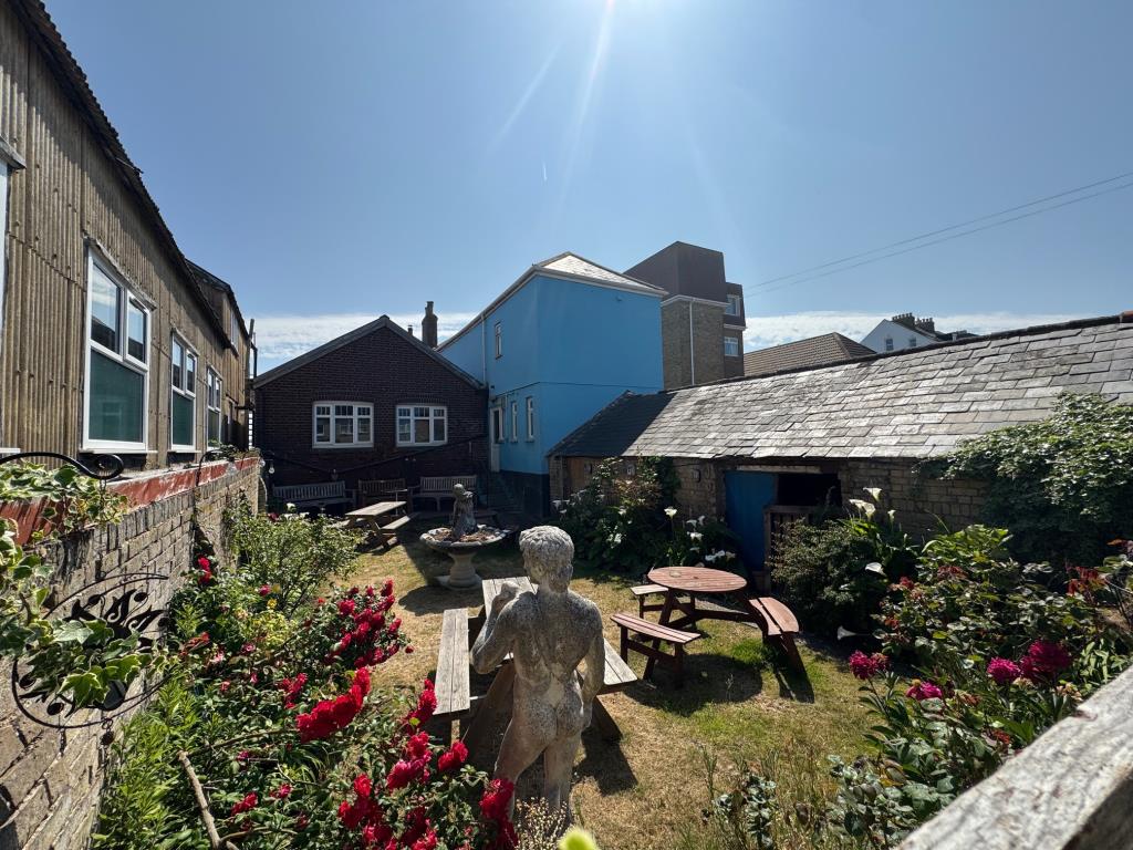 Lot: 122 - SEAFRONT PUBLIC HOUSE WITH THREE-BEDROOM FLAT WITH SEA VIEWS - Garden and single storey store and log store